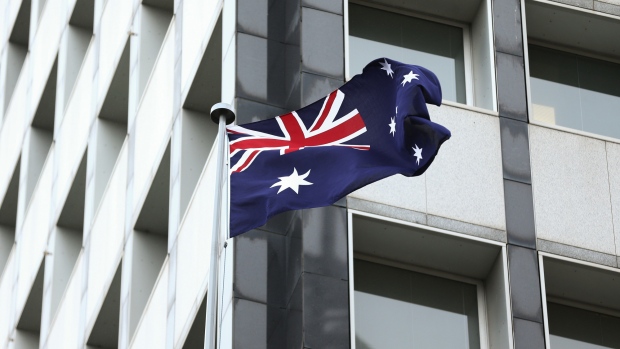 The Australian flag flies outside the Reserve Bank of Australia (RBA) headquarters in Sydney, Australia, on Monday, Dec. 4, 2017. Australia's central bank is on track for its longest stretch of unchanged interest rates as it bets a tightening job market will begin to put upward pressure on wages -- at some stage. 