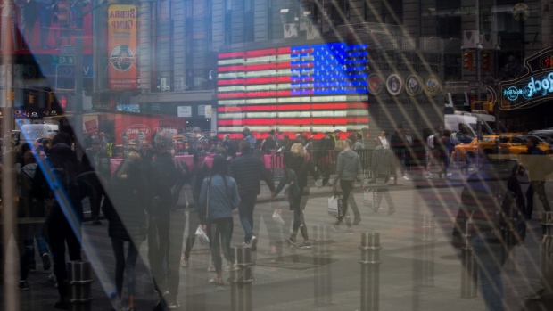 Pedestrians are reflected in a window of the Nasdaq MarketSite in the Times Square neighborhood of New York, U.S., on Monday, April 8, 2019. U.S. stocks pared losses as investors awaited signs of progress in the trade war with China ahead of the latest corporate earnings season. 