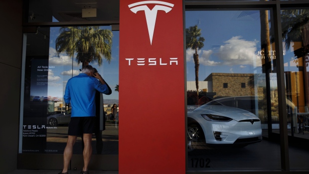 A pedestrian looks inside a closed Tesla Inc. store in Palm Desert, California, U.S., on Thursday, March 7, 2019.