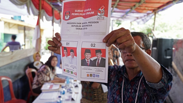 An election official holds a ballot during the counting for the general elections at a polling station in Jakarta, Indonesia, on Wednesday, April 17, 2019. Indonesians have voted in the world’s biggest single-day election, with unofficial tallies putting President Joko Widodo ahead with 55 percent with around 38 percent of votes counted. 
