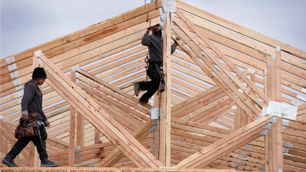 Workers install roof trusses on a home under construction in Vineyard, Utah. 