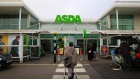 A customer pushes a shopping cart as she walks towards an Asda supermarket, operated by Wal-Mart Stores Inc., in the Wembley district of London, U.K. 
