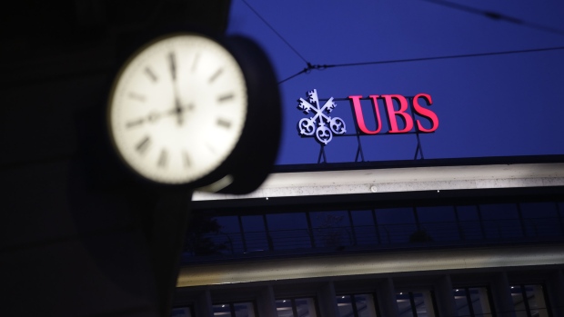 A sign sits illuminated on the roof of the UBS Group AG headquarters in Zurich, Switzerland, on Monday, May 2, 2016. UBS said first-quarter profit plunged 64 percent, missing analyst estimates, as market turbulence eroded earnings at the wealth-management and securities units. 
