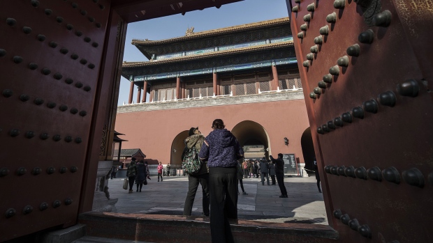 Visitors walk through a gate inside the Palace Museum at the Forbidden City in Beijing, 