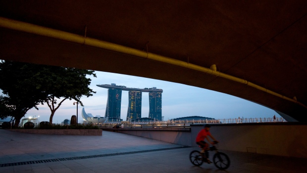A cyclist rides underneath a bridge at the Marina Bay waterfront as the Marina Bay Sands hotel and casino stands in the background in Singapore, on Sunday, June 10, 2018. U.S. President Donald Trump and North Korean leader Kim Jong Un will hold their historic Singapore summit at the Capella Hotel on the city-states Sentosa Island on June 12. 