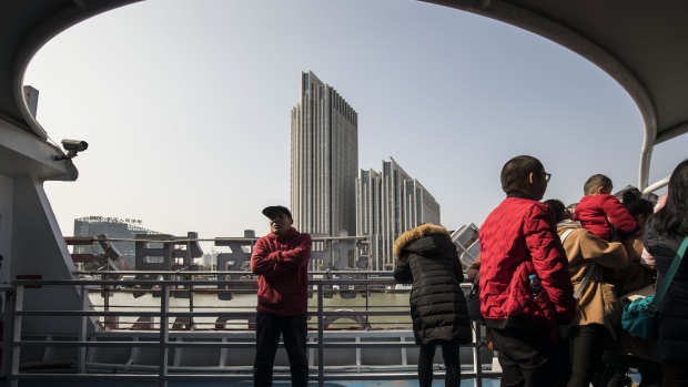 Tourists ride on a ferry crossing the Huangpu River as the Bund Soho building complex stands in the Lujiazui Financial District in Shanghai, China, on Monday, Feb. 26, 2018. Xi Jinping's decision to cast aside China's presidential term limits is stoking concern he also intends to shun international rules on trade and finance, even as he champions them on the world stage. 