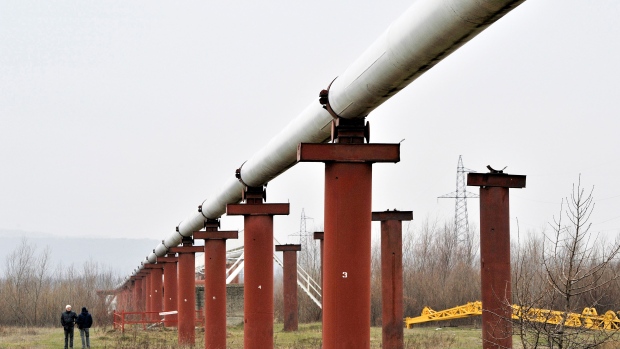 Men stand near the Druzhba crude oil pipeline, operated by UkrTransNafta