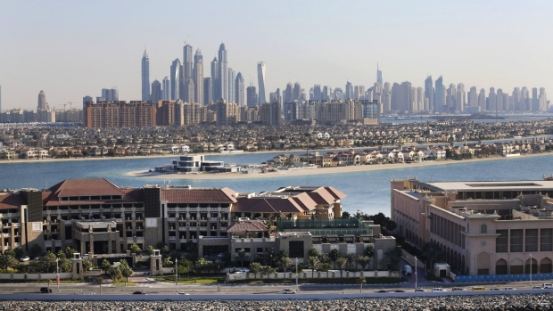 Residential villas sit on fronds of the Jumeirah Palm island resort archipelago as skyscrapers sit beyond on the city skyline in Dubai, United Arab Emirates, on Tuesday, Nov. 11, 2014