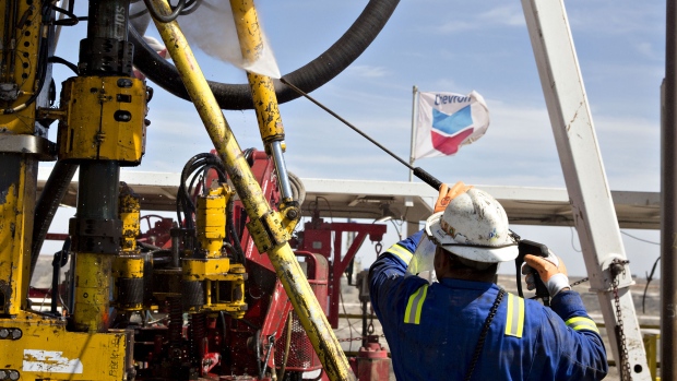 A Chevron Corp. flag flies on the drilling floor of a Nabors Industries Ltd. drill rig in the Permian Basin near Midland, Texas, U.S., on Thursday, March 1, 2018. Chevron, the world's third-largest publicly traded oil producer, is spending $3.3 billion this year in the Permian and an additional $1 billion in other shale basins. Its expansion will further bolster U.S. oil output, which already exceeds 10 million barrels a day, surpassing the record set in 1970. 