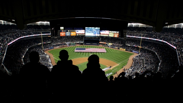 NEW YORK, NY - OCTOBER 13: Fans stand as a giant American flag is stretched across the outfield during the performance of the National Anthem between the New York Yankees and the Detroit Tigers during Game One of the American League Championship Series at Yankee Stadium on October 13, 2012 in the Bronx borough of New York City, New York. (Photo by Alex Trautwig/Getty Images) 