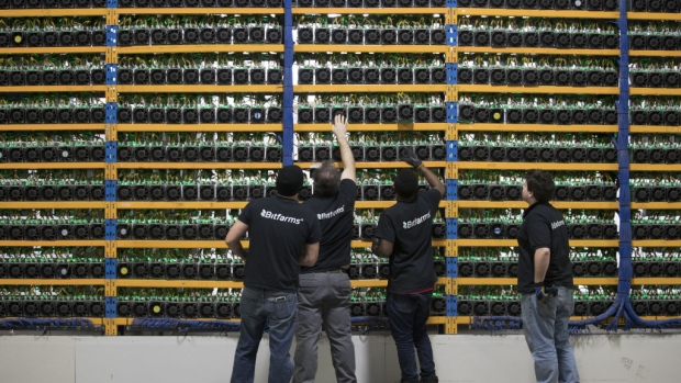 FILE: Employees check fans on mining machines at the Bitfarms cryptocurrency farming facility in Farnham, Quebec, Canada, on Wednesday, Jan. 24, 2018. The great cryptocurrency crash of 2018 is heading for its worst week yet. Bitcoin sank toward $4,000 and most of its peers tumbled on Friday, extending the Bloomberg Galaxy Crypto Indexs weekly decline to 25 percent. Thats the worst five-day stretch since crypto-mania peaked in early January. 