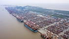 Container ships are docked next to gantry cranes as shipping containers sit stacked at the Yangshan Deepwater Port, operated by Shanghai International Port Group Co. (SIPG), in this aerial photograph taken in Shanghai. 