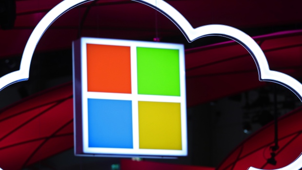 Microsoft Corp. logo, center, hang beside an illuminated iCloud icon at the CeBIT 2017 tech fair in Hannover, Germany. 