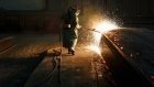 Sparks fly as an employee performs a quality check on a steel slab at a plant in Nanticoke, Ontario, Canada. 