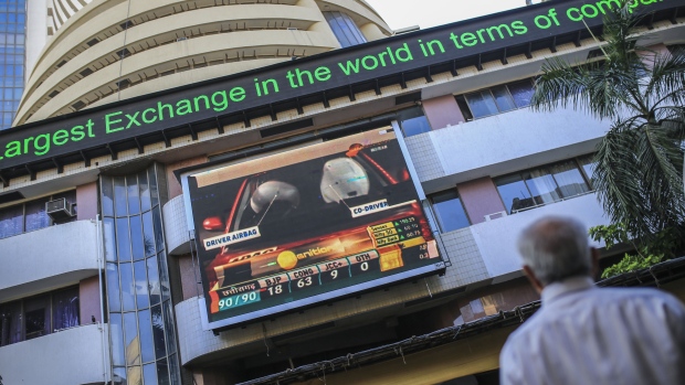 A man looks toward a screen and an electronic ticker board outside the Bombay Stock Exchange (BSE) building in Mumbai, India, on Tuesday, Dec. 11, 2018. India’s new central bank governor has a list of challenges to face as he takes office: from fixing a banking crisis to convincing investors of the institution’s autonomy. 