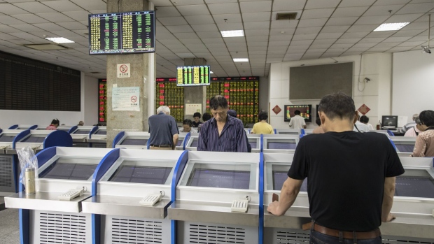 Investors stand in front of trading terminals at a securities brokerage in Shanghai, China, on Wednesday, May 30, 2018. Foreign investors are about to get a bargain. At least, that's the optimistic slant after Chinese equities slumped for the longest stretch since 2013, taking valuations back to two-year lows right before they feature on MSCI Inc. indexes from June 1. 
