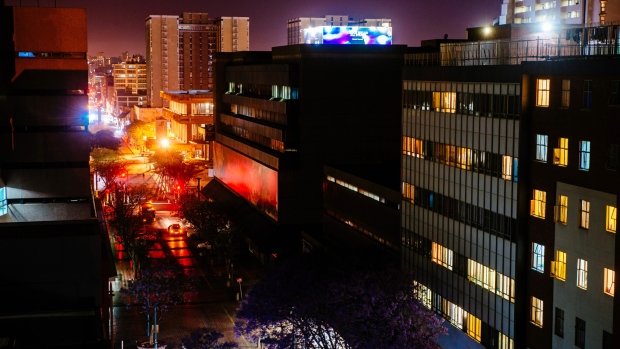 Electrical lights illuminate commercial office buildings at night in Pretoria. 