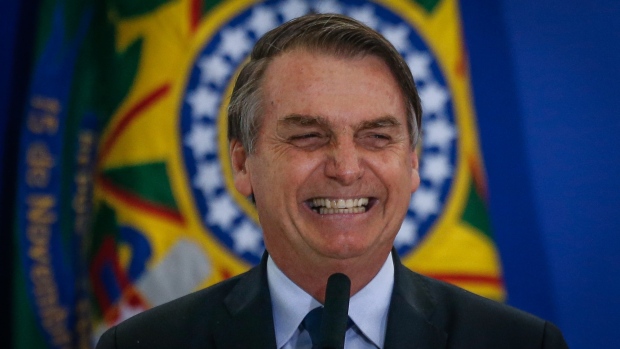 Jair Bolsonaro, Brazil's president, smiles during a ceremony with military officials at the Planalto Palace in Brasilia, Brazil, on Friday, April 5, 2019. On Friday Bolsonaro met with newly minted military brass, this after a backlash against his commemoration of a 1964 military coup d'etat that led to a two decade dictatorship in Brazil. Photographer: Andre Coelho/Bloomberg