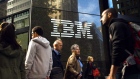 Pedestrians walk past an International Business Machines Corp. (IBM) logo that is displayed in front of the company's offices in New York, U.S., on Monday, Oct. 14, 2013. International Business Machines is scheduled to report 3Q results post-market tomorrow. 