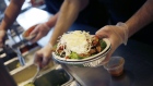 An employee prepares a burrito bowl at a Chipotle. Photographer: Luke Sharrett/Bloomberg