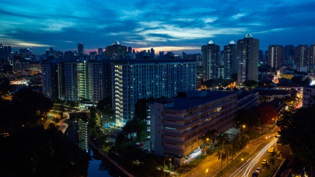 Residential and commercial buildings stand illuminated at dusk in the Kallang area of Singapore, on Saturday, Sept. 17, 2016. Singapore is currently mired in its most prolonged housing slump on record. Home prices in the city-state fell for the 11th straight quarter in the three months ending June 30, posting the longest losing streak since records started in 1975. 