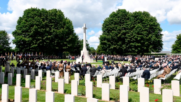 Guests attend ceremony at the Commonwealth War Graves cemetery as part of D-Day celebrations June 6