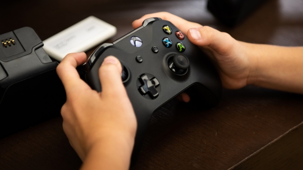 A customer holds a Microsoft Corp. XBox One game controller at the company's flagship store in New York, U.S., on Saturday, July 14, 2018. 