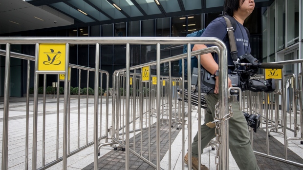 A pedestrian walks past barricades along the perimeter of the Legislative Council building in Hong Kong. Photographer: Paul Yeung/Bloomberg