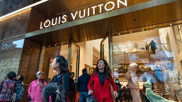 Shoppers exit a Louis Vuitton store on Canton Road in the Tsim Sha Tsui district of Hong Kong