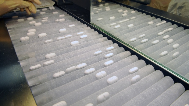 An employee uses a machine that sorts pills 