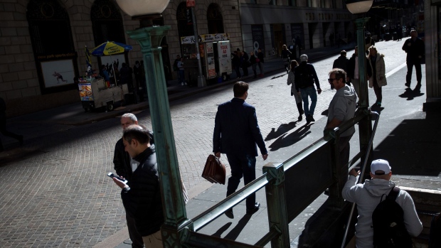 Pedestrians walk along Wall Street near the New York Stock Exchange. 