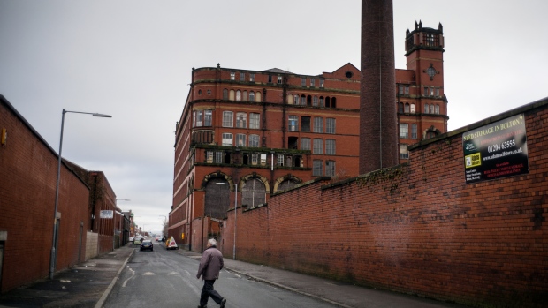 BOLTON, UNITED KINGDOM - FEBRUARY 09: A man walks past the former mighty Swan Lane Mill which is now partly derelict in Bolton on February 9, 2015 in Bolton, United Kingdom. As the United Kingdom prepares to vote in the May 7th general election many people are debating some of the many key issues that they face in their life, employment, the NHS, housing, benefits, education, immigration, 'the North South divide, austerity, EU membership and the environment. (Photo by Christopher Furlong/Getty Images)