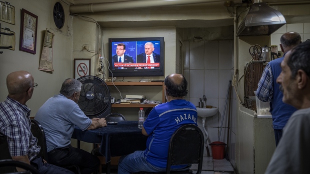 ISTANBUL, TURKEY - JUNE 16: A man watches on as Istanbul mayoral candidate Ekrem Imamoglu of the Republican People’s Party (CHP) (L) and Istanbul mayoral candidate Binali Yildirim of the ruling Justice and Development Party (AKP) are seen on a big screen during a live television debate on June 16, 2019 in Istanbul, Turkey. Anticipation has grown across Istanbul ahead of the live televised debate for the June 23 re-run Istanbul elections, outdoor viewing areas have been set up across parts of Istanbul for the historic debate, the last major political debate took place in Turkey in 2002. Imamoglu won a narrow victory during the first mayoral election held in March, defeating the candidate from President Erdogan's Justice and Development Party (AKP). But Turkey’s election body annulled the result after claims of “voting irregularities,” and a re-run election was announced for June 23. (Photo by Chris McGrath/Getty Images) Photographer: Chris McGrath/Getty Images Europe