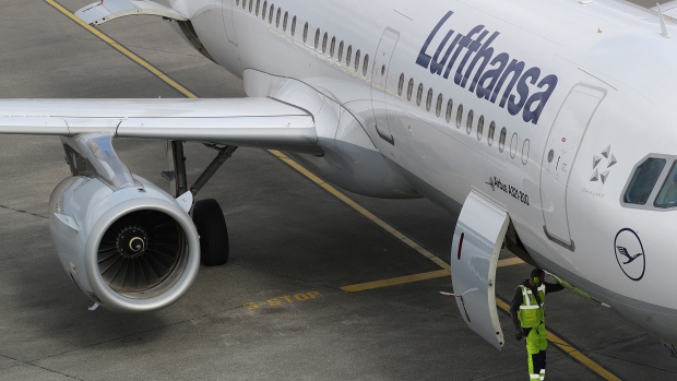 A ground crew member stands beneath an Airbus A321 aircraft, operated by Deutsche Lufthansa AG, at Tegel airport in Berlin, Germany, on Wednesday, March 13, 2019. Boeing Co. staggered into a deepening global crisis as governments around the world grounded the company's best-selling jet over safety concerns after a second deadly crash. 