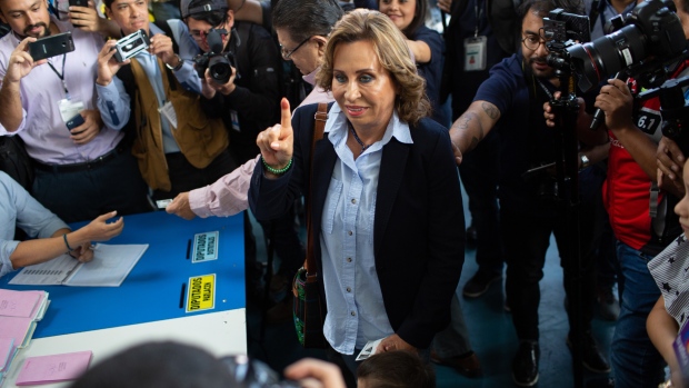 Sandra Torres, presidential candidate and former first lady, center, displays an inked finger after voting during presidential elections in Guatemala City, Guatemala, on Sunday, June 16, 2019. A former first lady and an ex-director of prisons are the front-runners as polls open in Guatemala's presidential election, both pledging to tackle the poverty and violence that has driven migrants to flee to the U.S. Photographer: James Rodriguez/Bloomberg