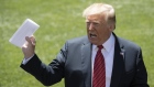 U.S. President Donald Trump holds up a page of what he described as a deal with Mexico while speaking to members of the media before boarding Marine One on the South Lawn of the White House in Washington, D.C., U.S., on Tuesday, June 11, 2019. Trump told reporters that he struck a secret deal with the Mexico that will take effect when he wants it to -- despite the country's insistence that there are no secret components of an immigration deal struck last week. 