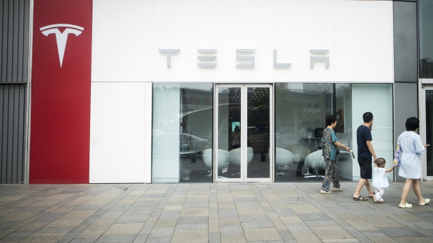 Pedestrians walk past a Tesla Inc. showroom in Beijing. 