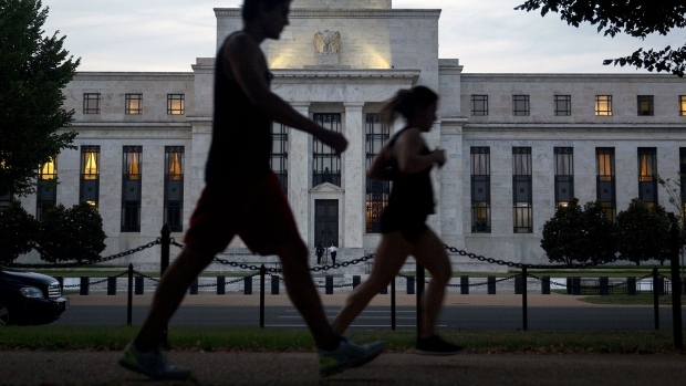 A pedestrian walks past the Marriner S. Eccles Federal Reserve building stands in this photograph taken with a tilt-shift lens in Washington, D.C., U.S., on Tuesday, Sept. 1, 2015. Bill Gross said the Federal Reserve has waited so long to raise interest rates that any move now may be labeled "too little too late" as market turmoil restricts the room for policy makers to act. 