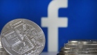 In this photo illustration, a visual representation of a digital cryptocurrency coin sits on display in front of a Facebook logo on June 17, 2019 in Paris, France. Facebook will announce Tuesday, June 18 the details of its cryptocurrency, called "Libra". Like bitcoin, the best-known virtual currency, it will rely on blockchain technology. 