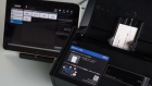 A tablet displaying a sample page of Sansan Inc.'s database, left, and a Fujitsu Ltd. ScanSnap iX500 Sansan Edition business card scanner. 