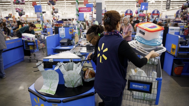 An cashier places items into a customer's shopping cart at a Walmart Inc. store in Burbank, California, U.S., on Monday, Nov. 19, 2018. To get the jump on Black Friday selling, retailers are launching Black Friday-like promotions in the weeks prior to the event since competition and price transparency are forcing retailers to grab as much share of the consumers' wallet as they can. 
