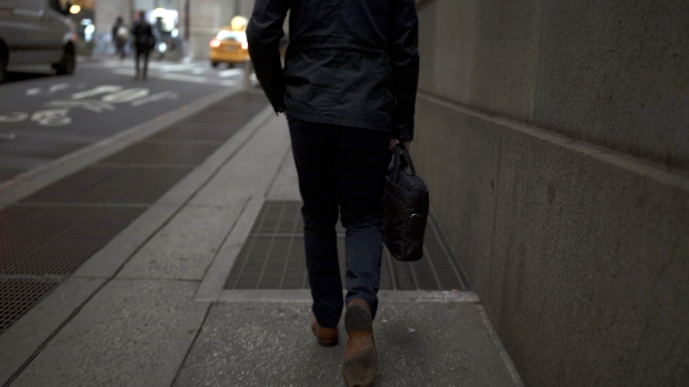 A pedestrian walks along a street near the New York Stock Exchange. 