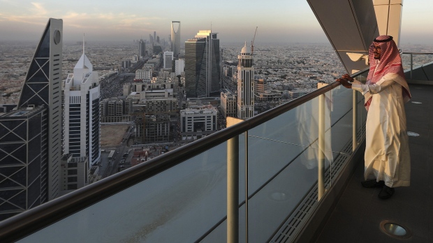 An employee looks out from the 32nd floor viewing platform of the Al Faisaliah Tower, as skyscrapers and commercial buildings stand beyond, in Riyadh, Saudi Arabia, on Thursday, Dec. 1, 2016. Saudi Arabia is working to reduce the Middle Easts biggest economys reliance on oil, which provides three-quarters of government revenue, as part of a plan for the biggest economic shakeup since the countrys founding. 