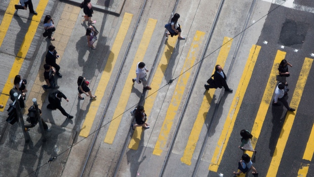 Commuters cross a street in the business district of Central in Hong Kong, China. 
