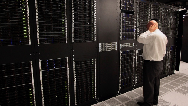 A public relations employee looks over racks of servers inside pod one of International Business Machines Corp.'s (IBM) Softlayer data center in Dallas. 