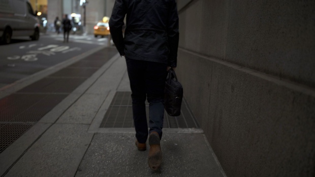 A pedestrian walks along a street near the New York Stock Exchange (NYSE) in New York, U.S., on Monday, Nov. 26, 2018 Beaten-down tech shares led the rebound in U.S. stocks, while Treasuries fell as investors gained confidence from positive political developments in Europe and rising oil prices. 