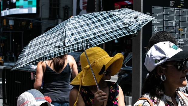 A person holds an umbrella in the Times Square area of New York, U.S., on Saturday, July 20, 2019. Consolidated Edison Inc. is forecasting record power demand for New York this weekend as a heat wave blankets the city. 