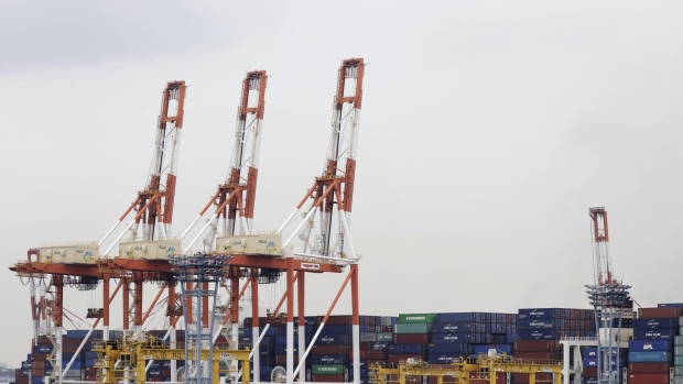 Stacked containers sit next to gantry cranes at a shipping terminal in Yokohama, Japan, on Thursday, July 11, 2019. Japan and South Korea plan to meet on Friday over Tokyo’s move to restrict vital exports to its neighbor, but neither has much political incentive to climb down from their worst dispute in decades. 