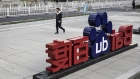 A man walks past a sign for Baidu Inc. at the entrance to the Baidu Technology Park in Beijing, China, on Friday, Nov. 25, 2016. Baidu serves 6 billion searches a day and dominates mobile mapping, which gives location data for its mobile users as well as those of apps built on its map data. 