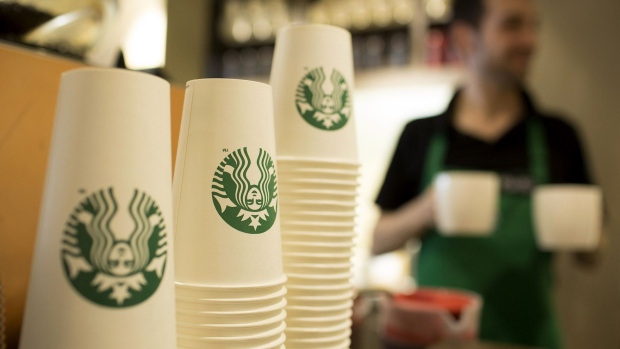 The Starbucks Corp. logo sits on cardboard coffee cups inside a Starbucks Corp. shop in London. 